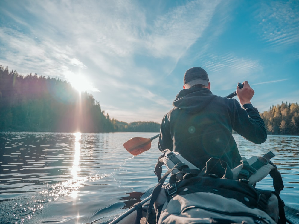 man in black jacket riding on boat during daytime