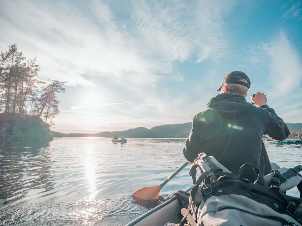 man in black jacket riding on boat during daytime