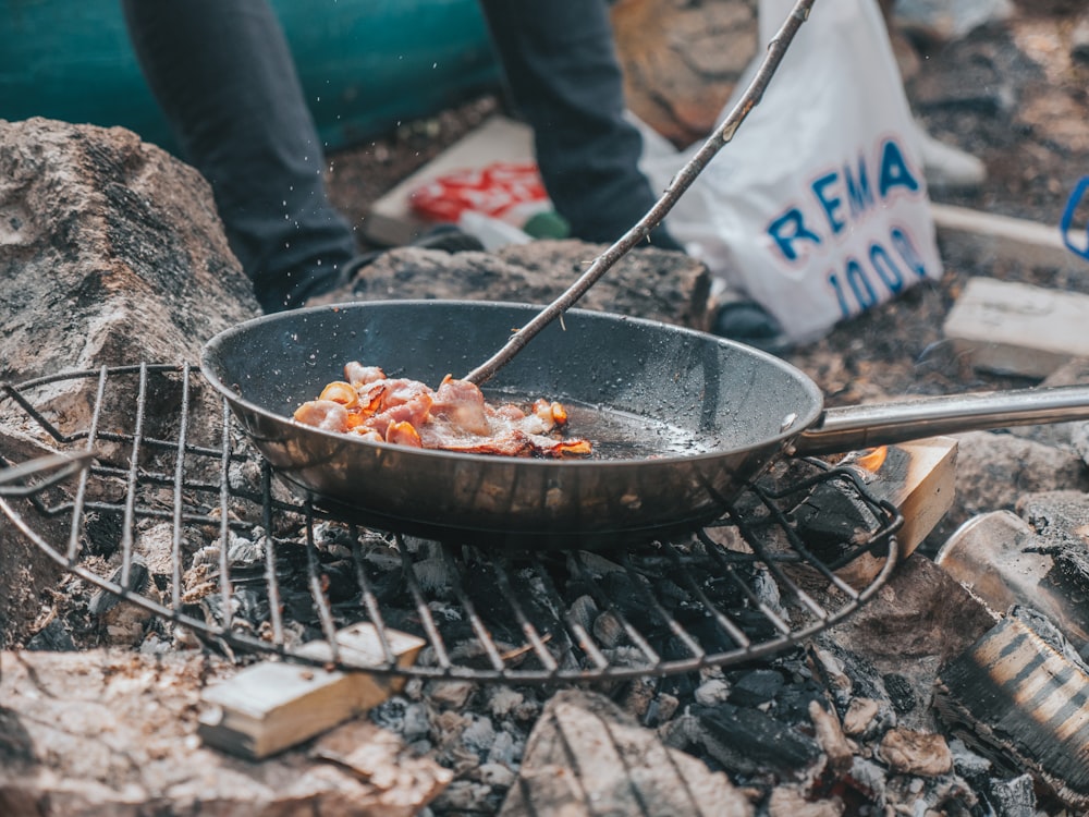 black frying pan on charcoal grill