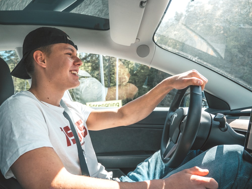 man in white crew neck t-shirt driving car