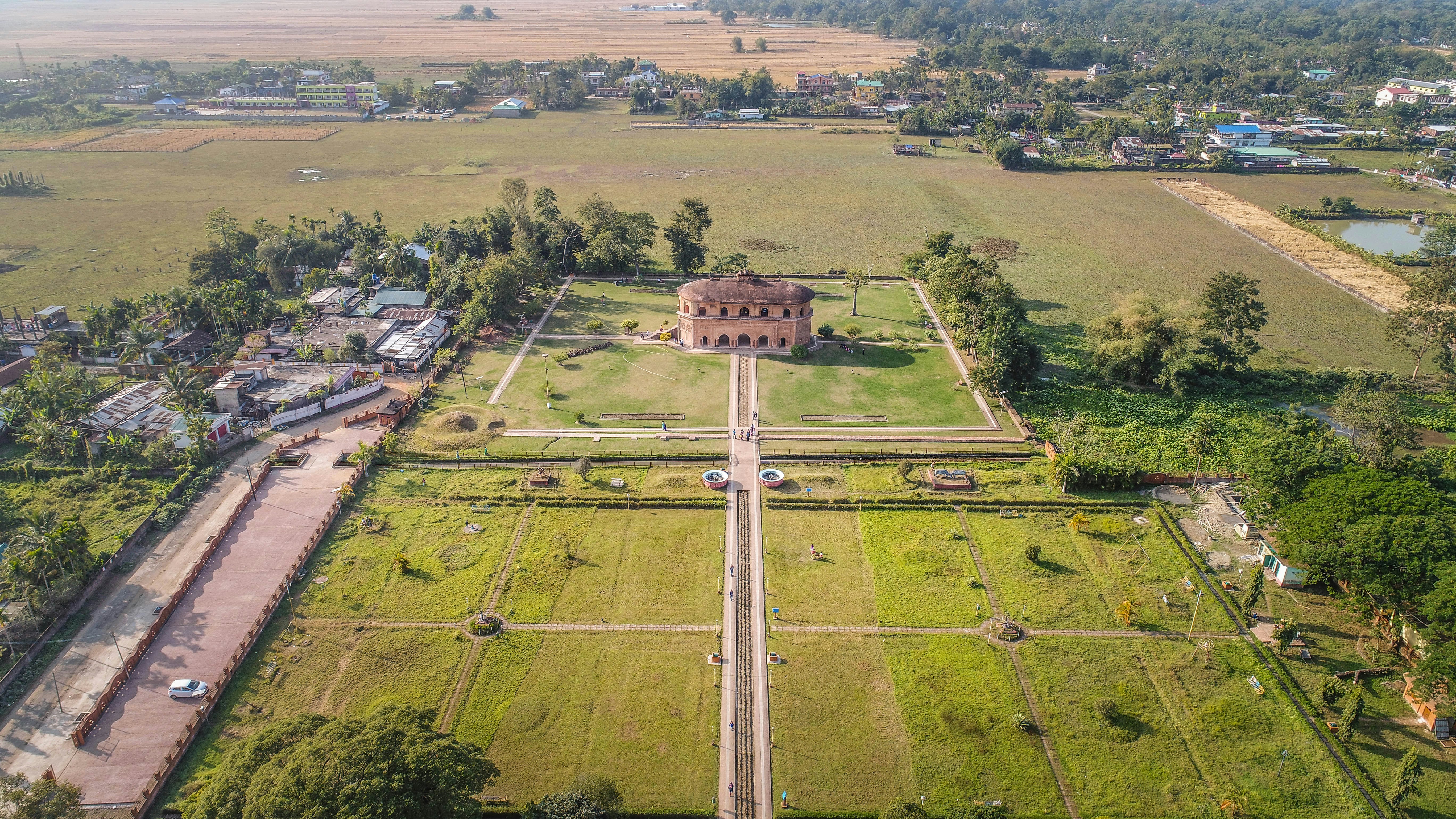 An aerial view of a large field with a house in the middle of it
