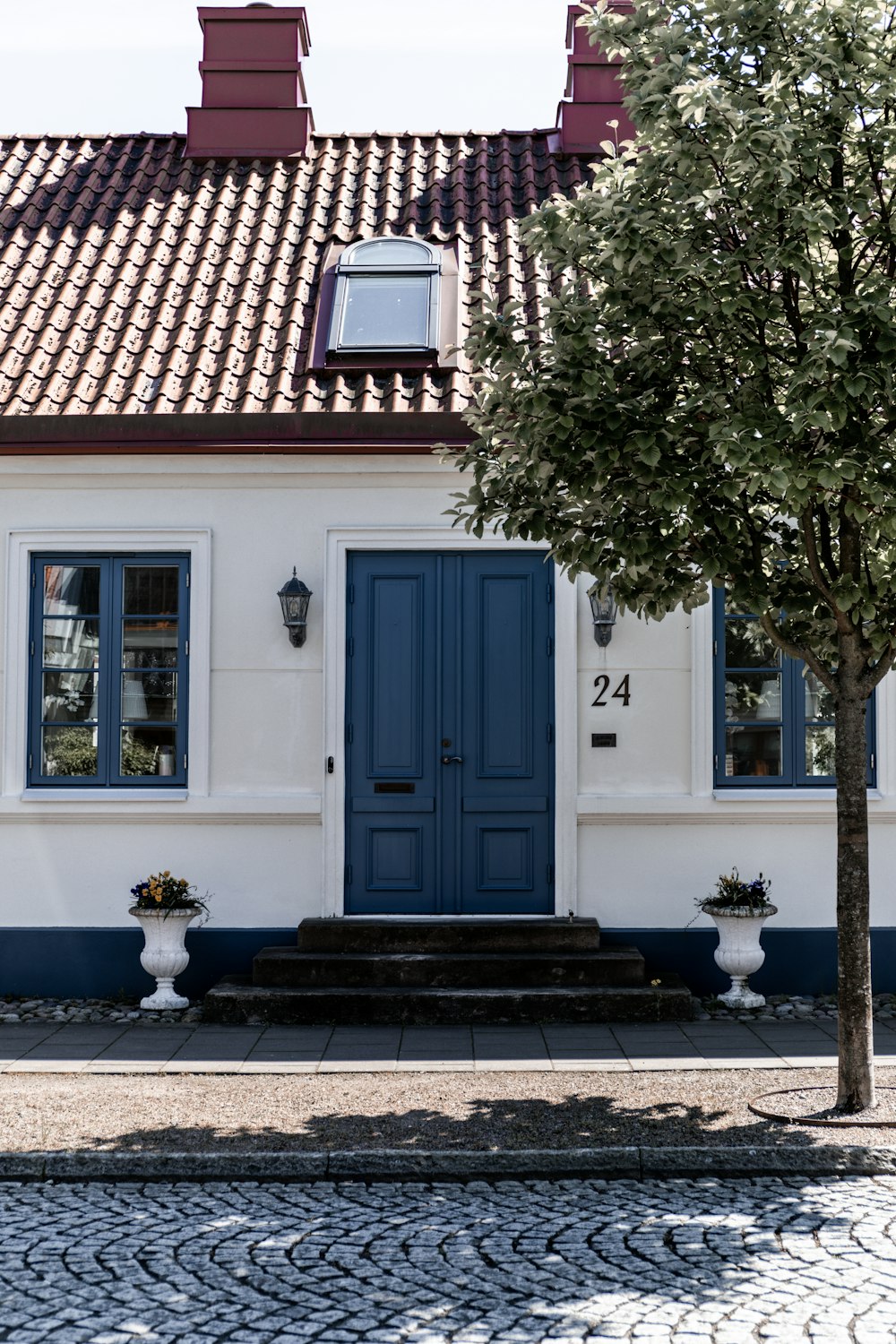 Blaue Holztür in der Nähe des grünen Baumes während des Tages