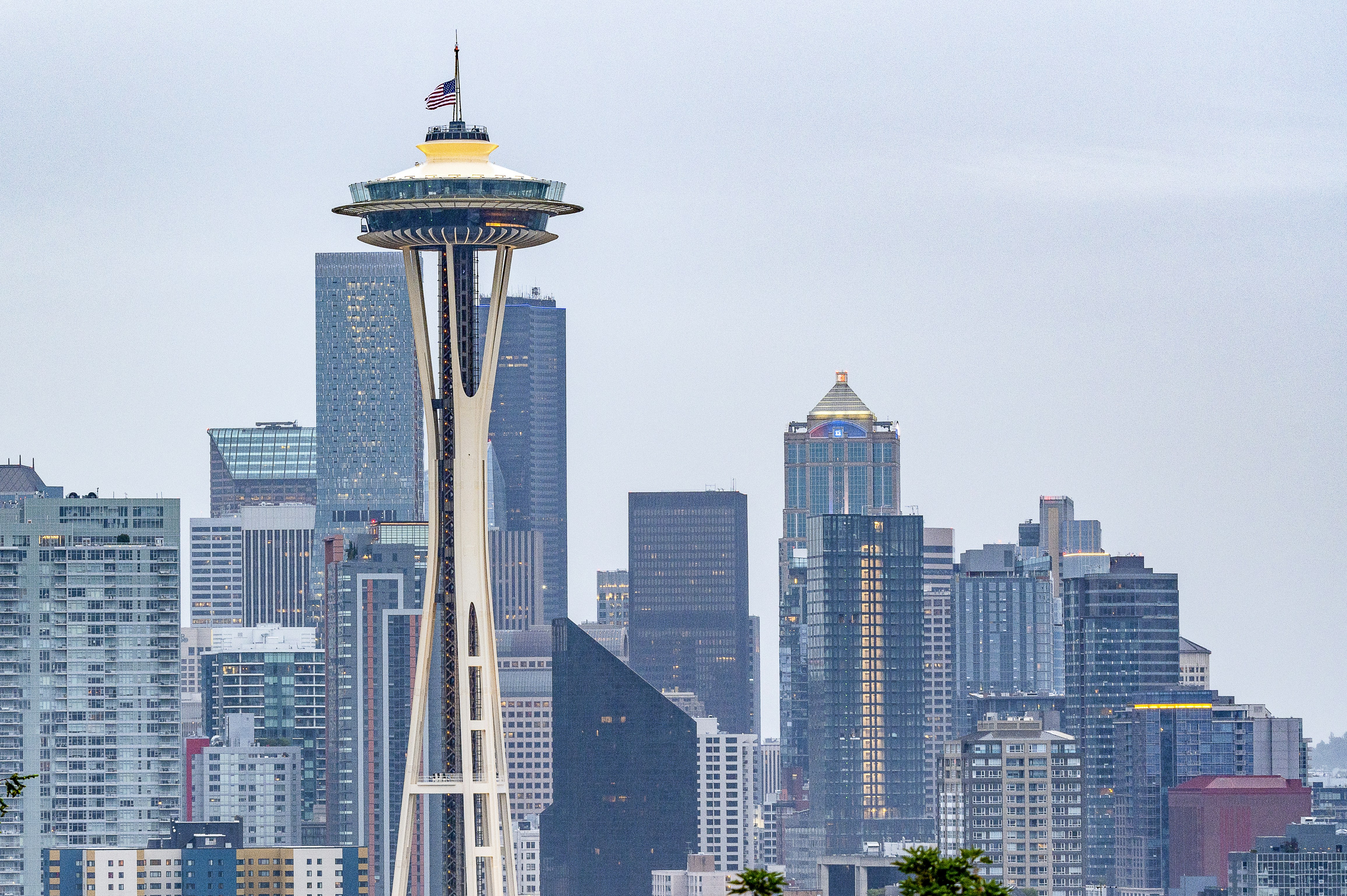 Picture of the Space Needle with the US Flag flying at half-staff, on Memorial Day 2020 with the city of Seattle visible. Taken shortly after sunrise on May 25, 2020. Seattle prepares to honor fallen soldiers in a unique way, due to social distancing.