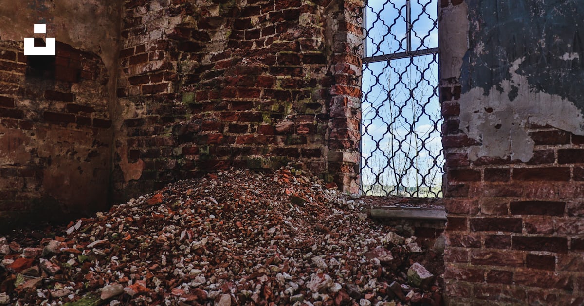A pile of rubble next to a window in an old building photo – Free Blue ...