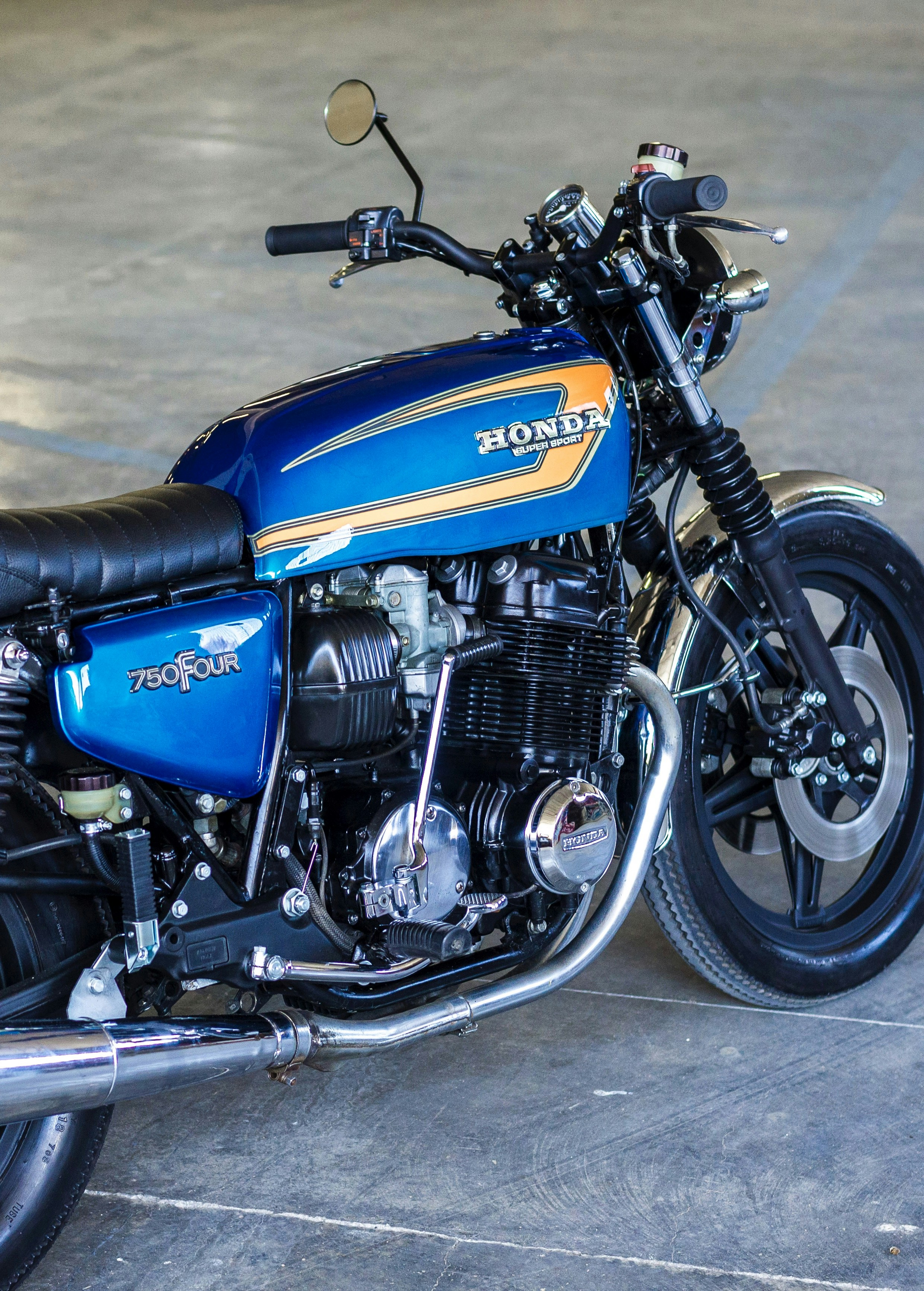 Motocicleta azul y negra sobre piso de concreto gris