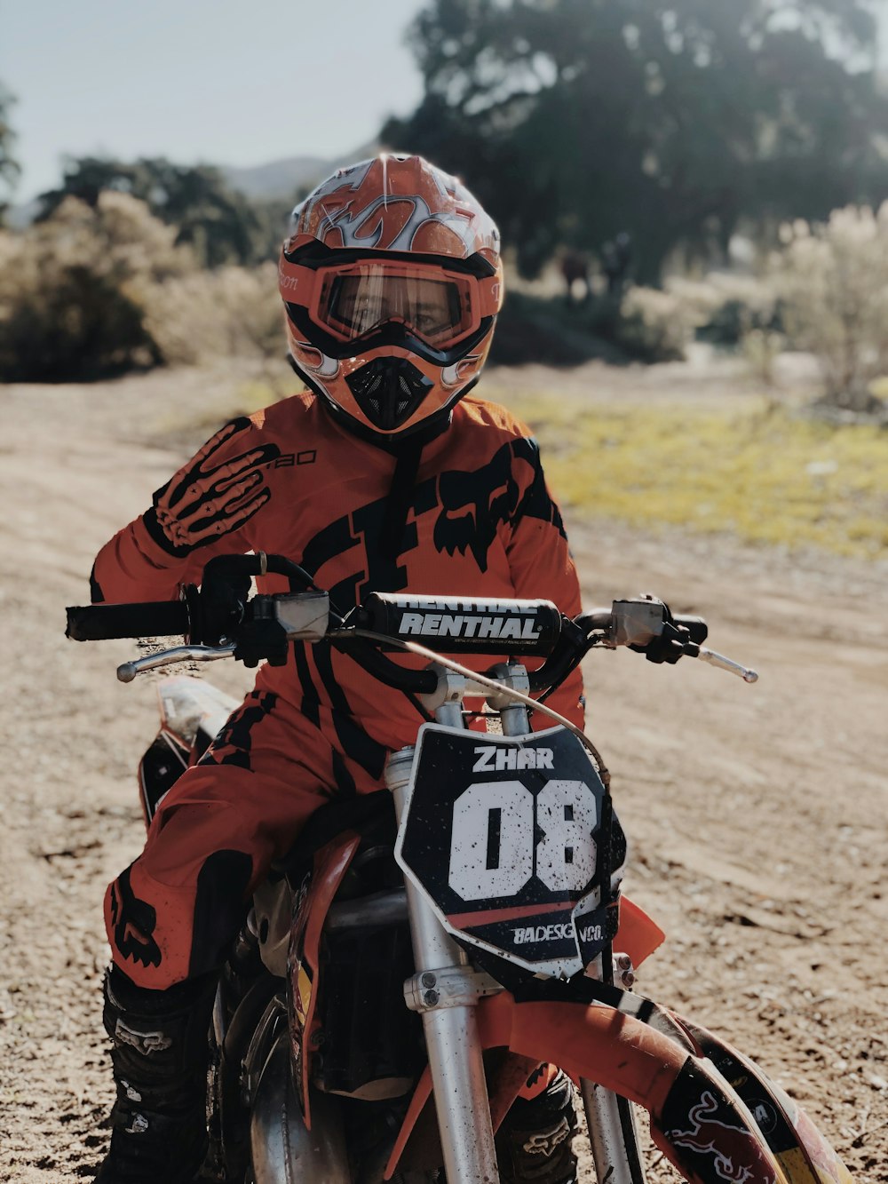 Hombre en traje de motocross naranja y negro montando motocross cross