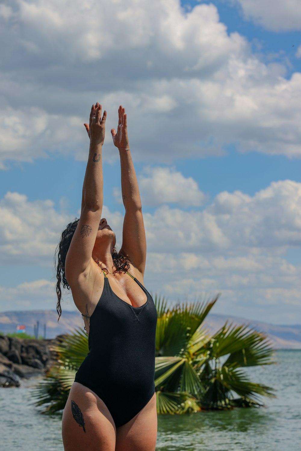 woman in black tank top raising her hands