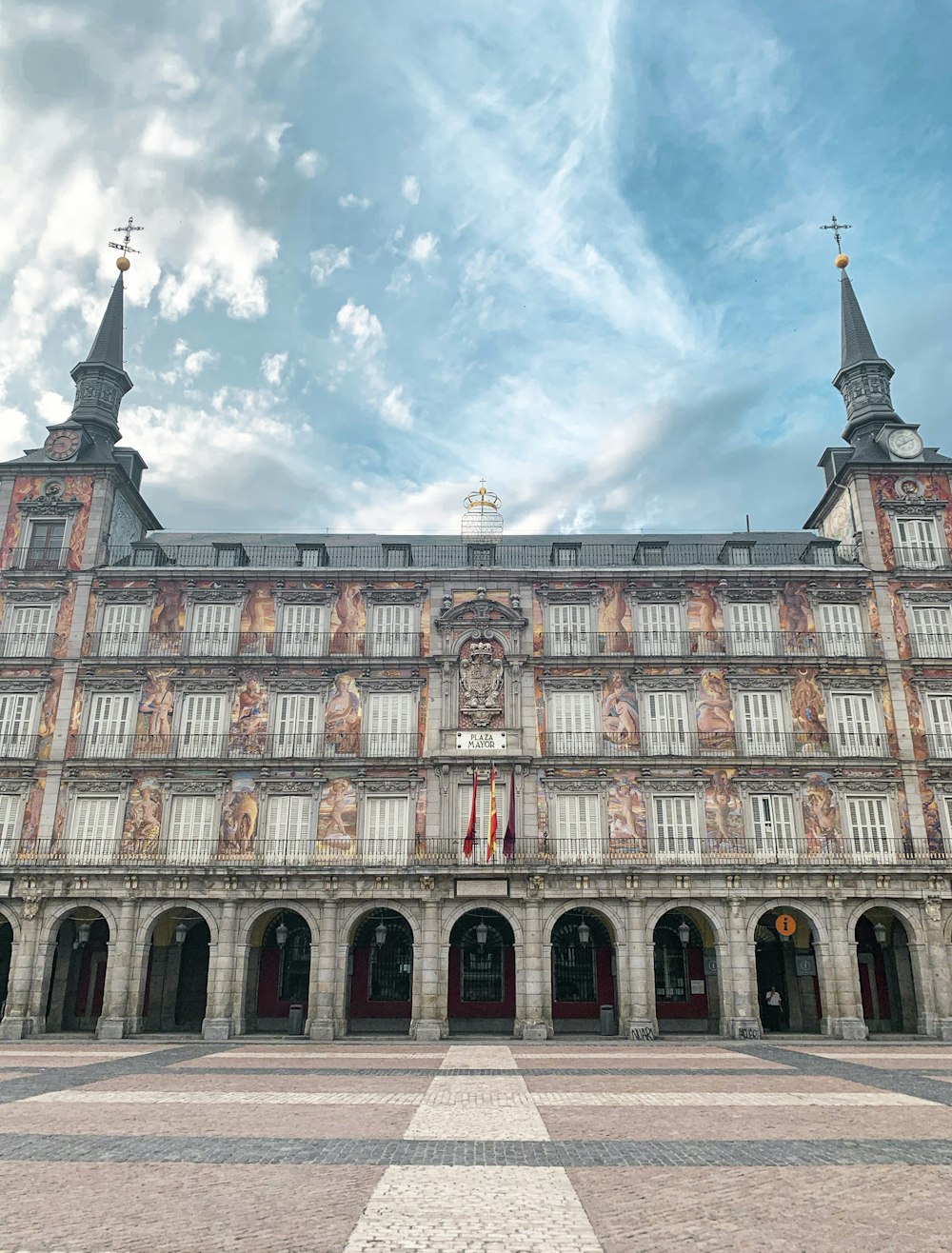 Edificio de hormigón marrón y blanco bajo nubes blancas y cielo azul durante el día