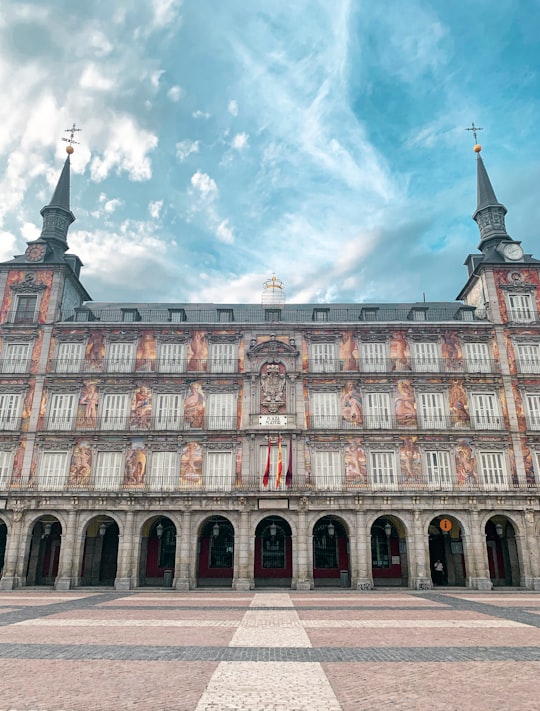 brown and white concrete building under white clouds and blue sky during daytime in Plaza Mayor Spain