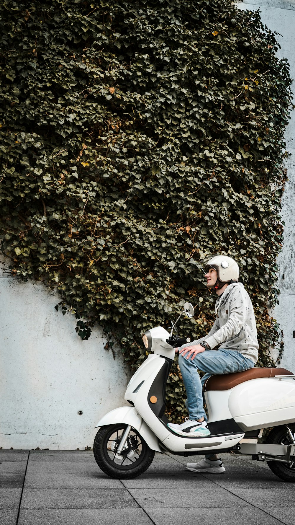 woman in blue denim jacket riding white motor scooter