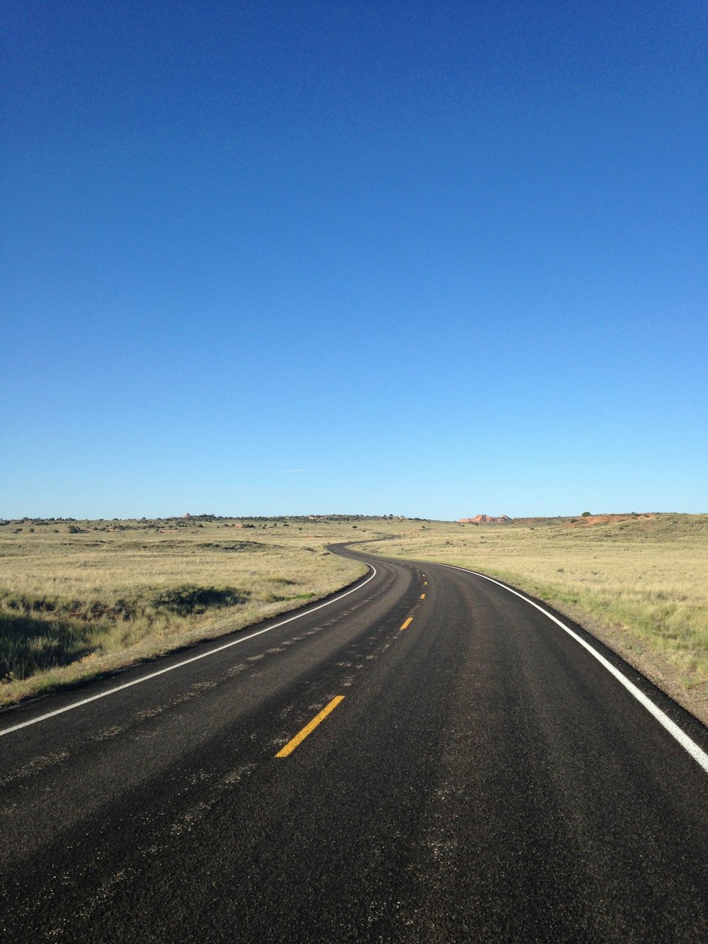black asphalt road under blue sky during daytime