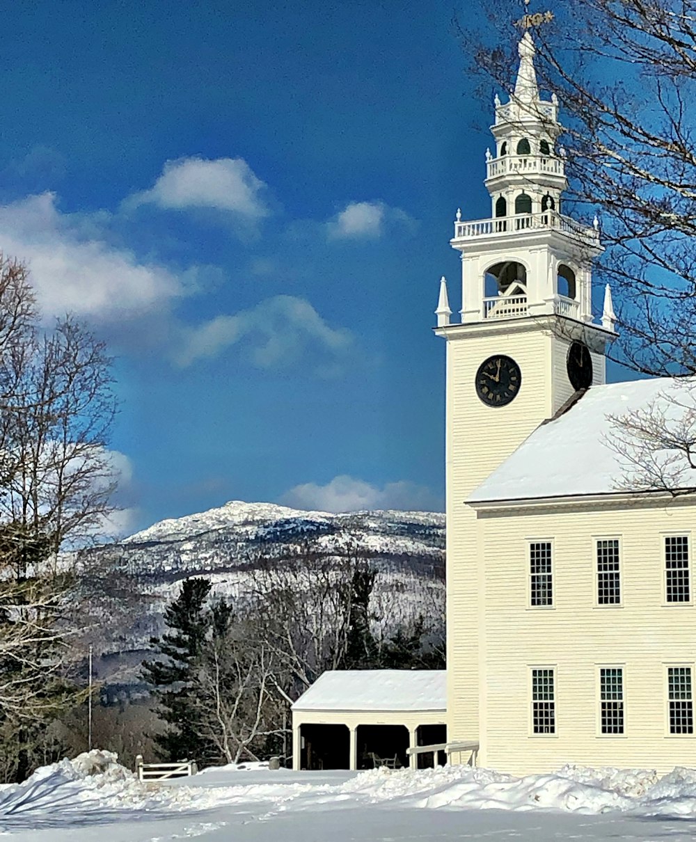 white and brown concrete building near snow covered mountain during daytime