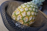 Close-up of a vibrant pineapple fruit bowl glowing softly on a black marble table.