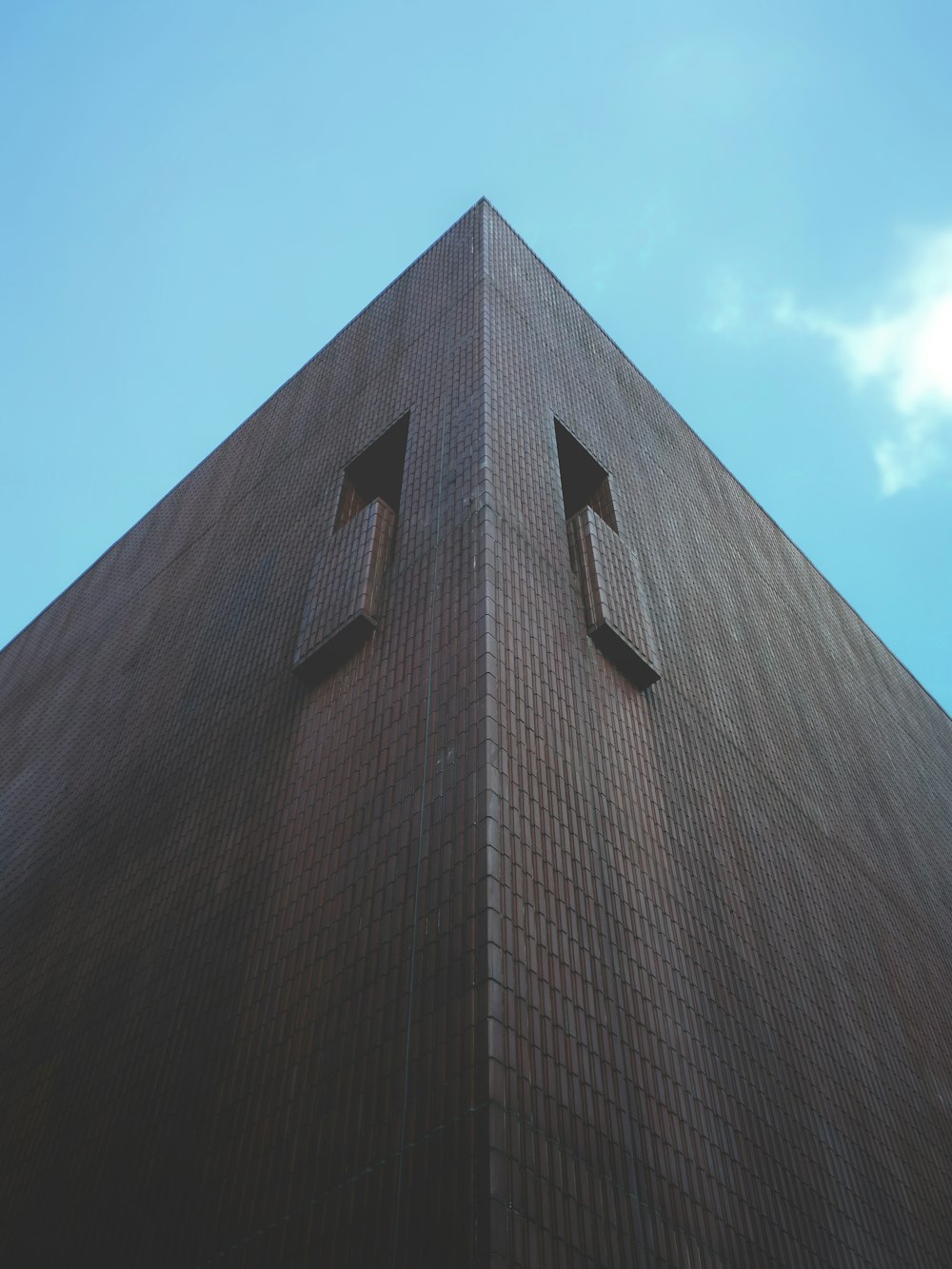 Braunes Betongebäude unter blauem Himmel tagsüber