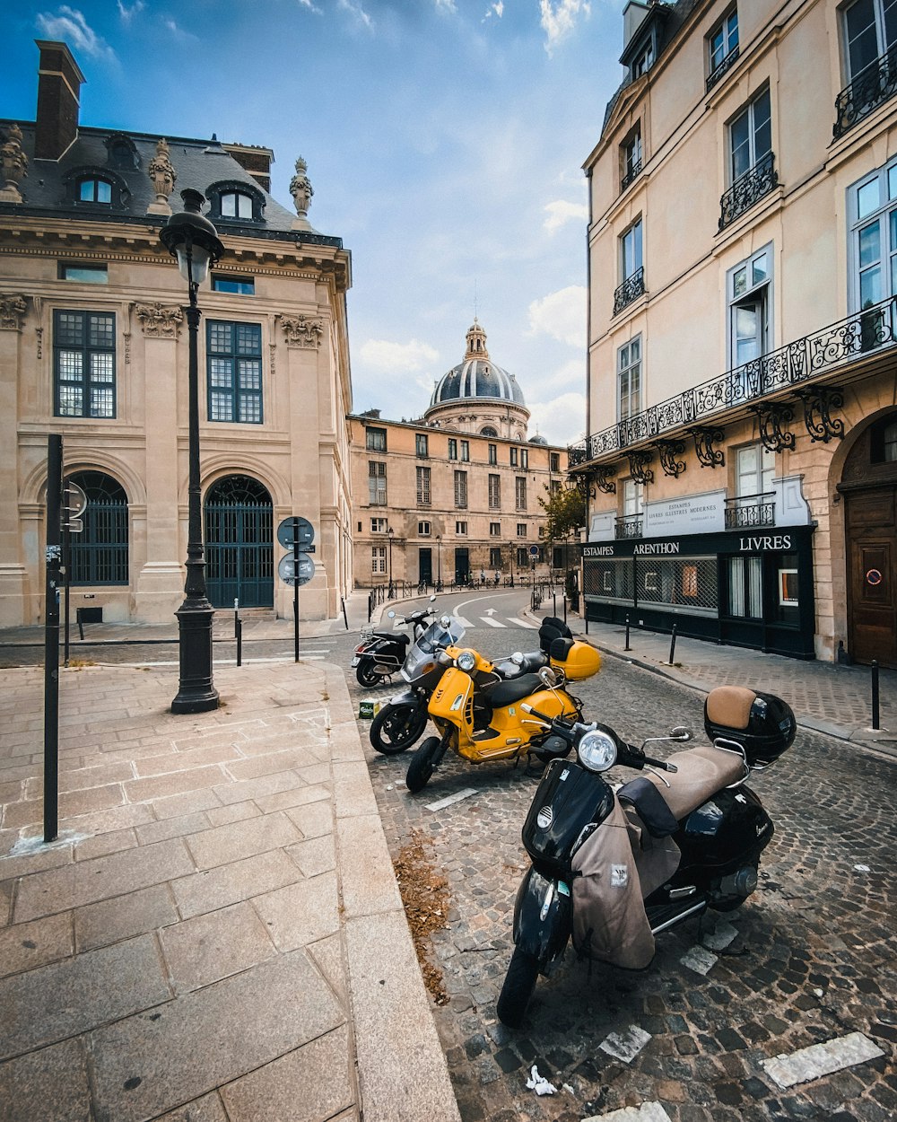 yellow and black sports bike parked beside black and yellow motorcycle near brown concrete building during