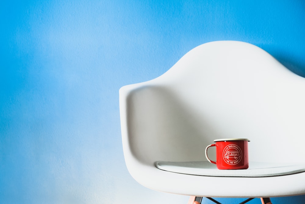 red ceramic mug on white ceramic sink