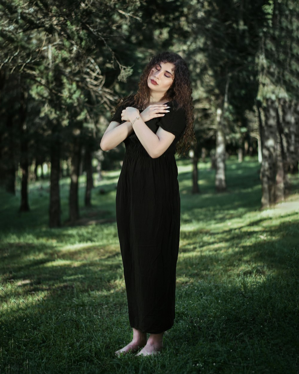 a woman in a black dress standing in the grass