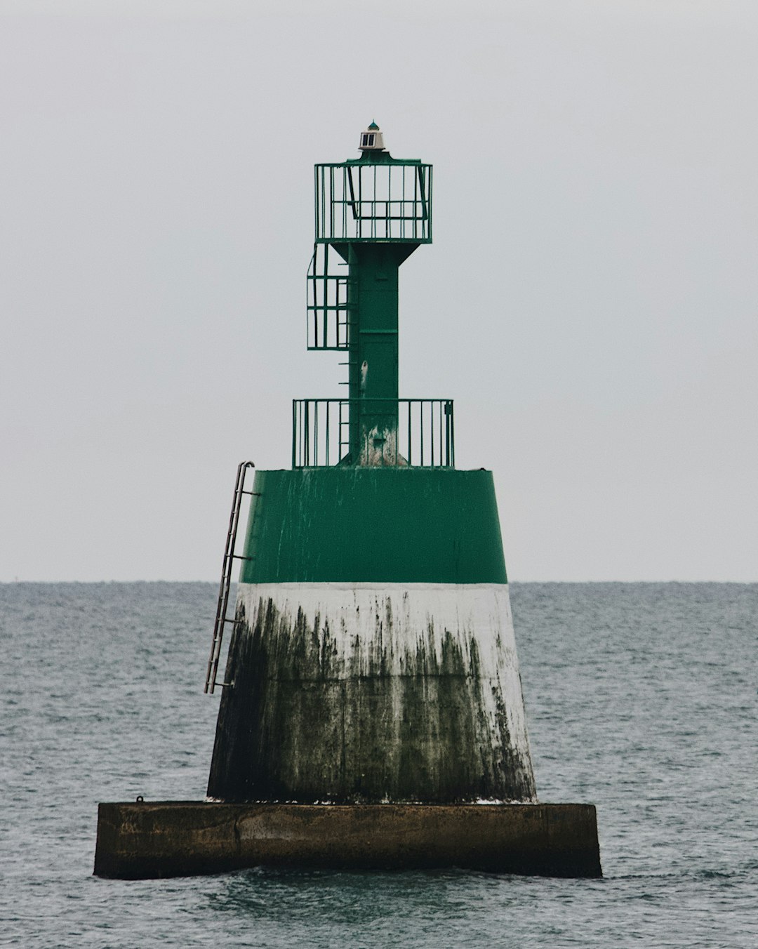 green and white lighthouse on brown wooden dock during daytime