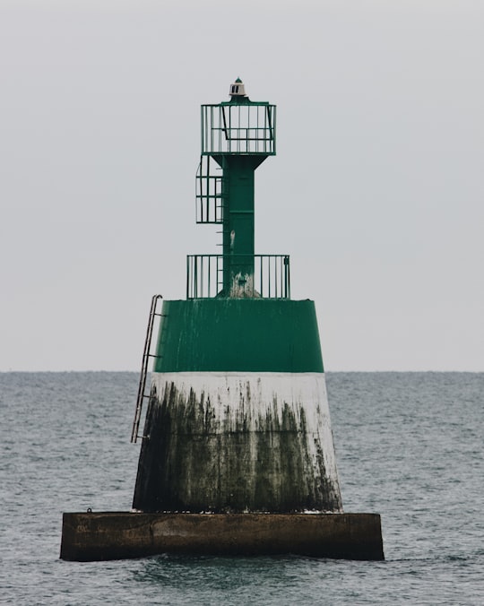 green and white lighthouse on brown wooden dock during daytime in Cap d'Agde France