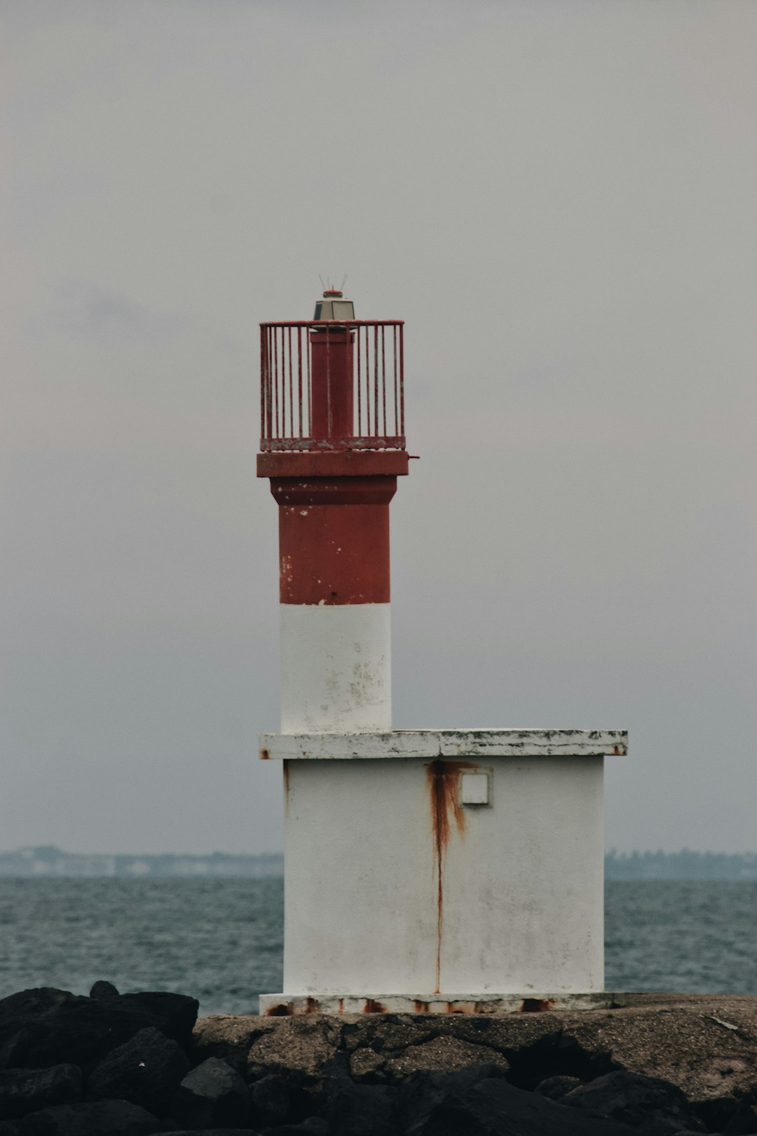 white and red lighthouse on the sea