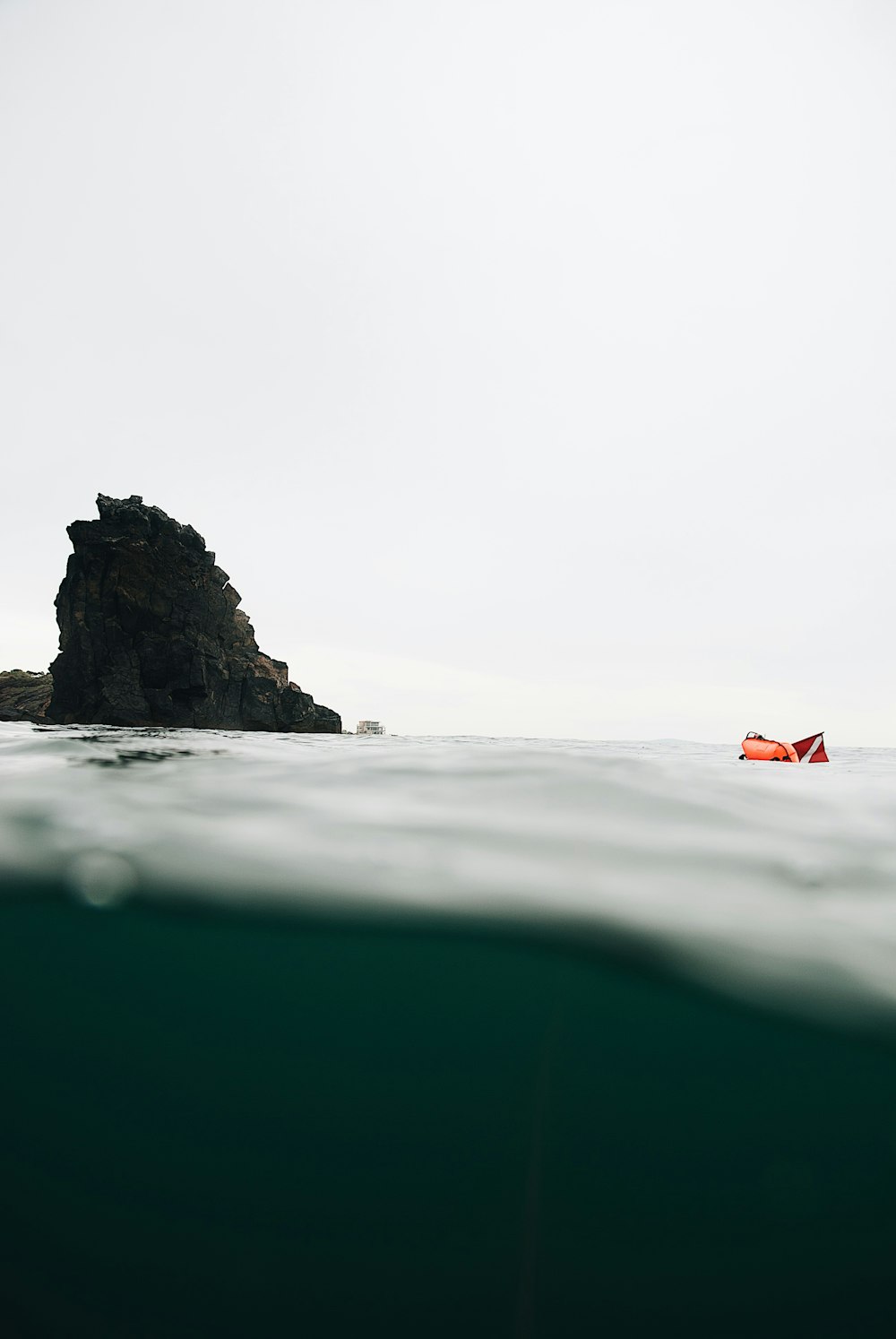 orange and white flag on black rock formation