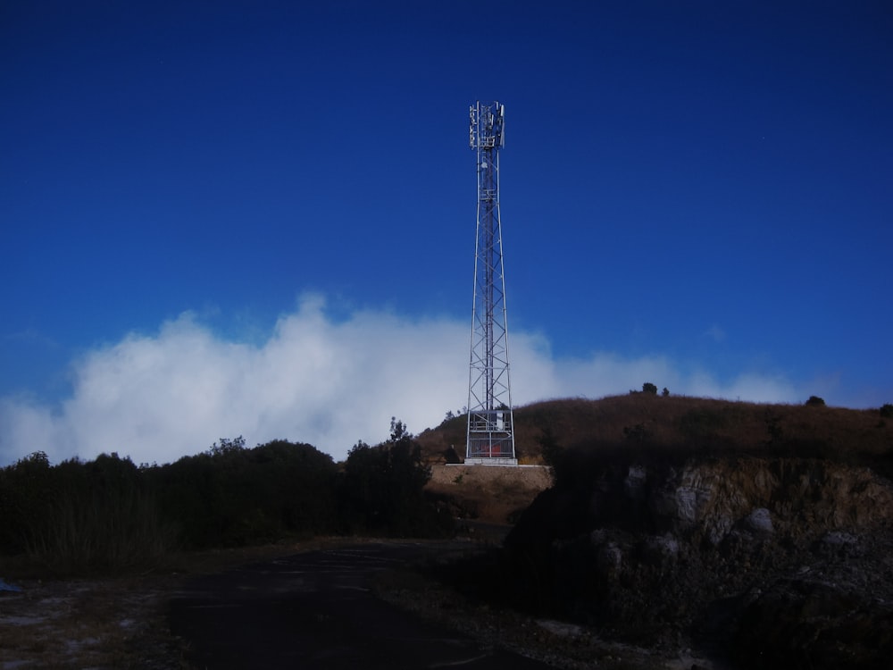 white metal tower on hill under blue sky during daytime