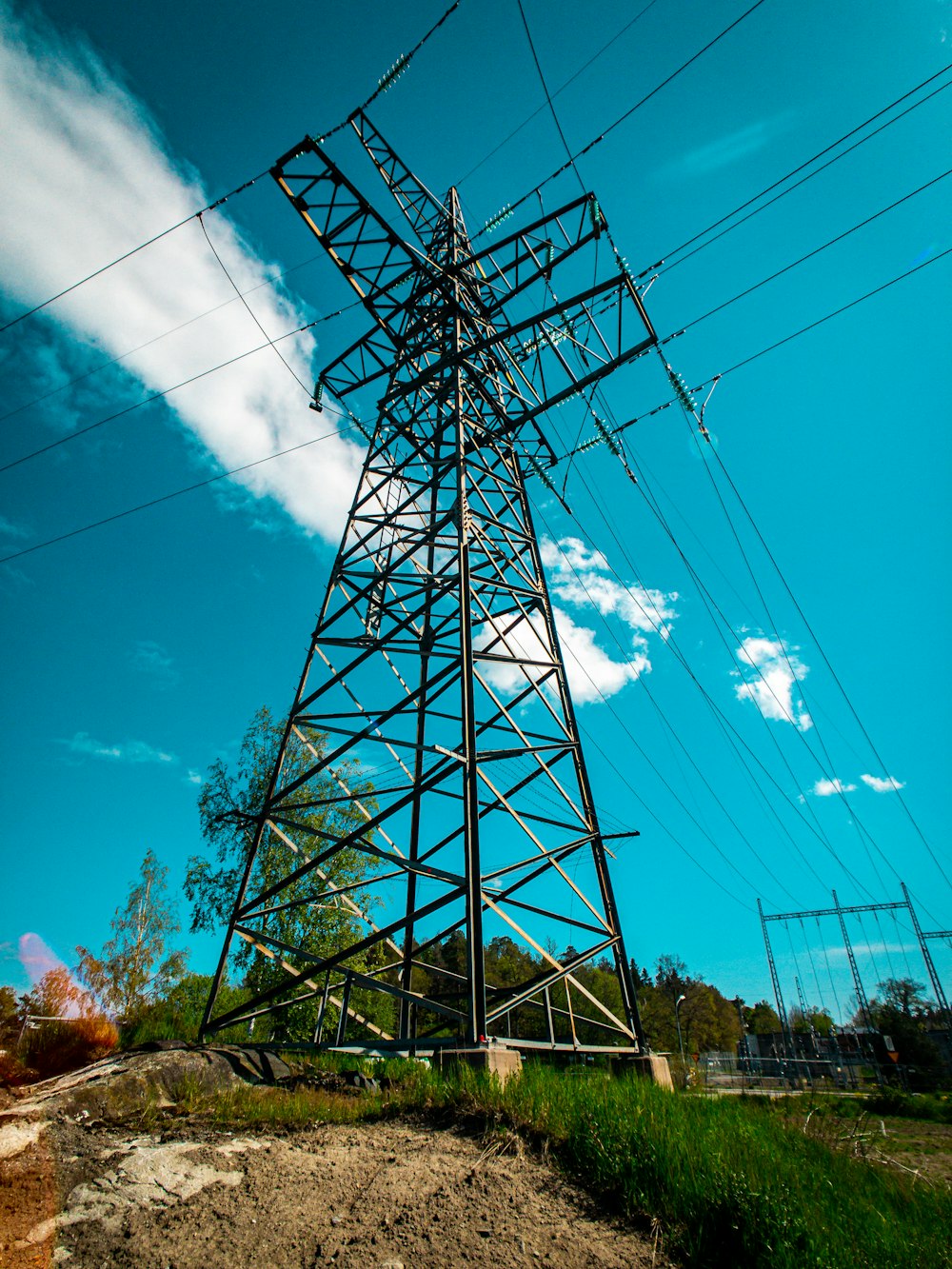 torre elétrica preta sob o céu azul e nuvens brancas durante o dia