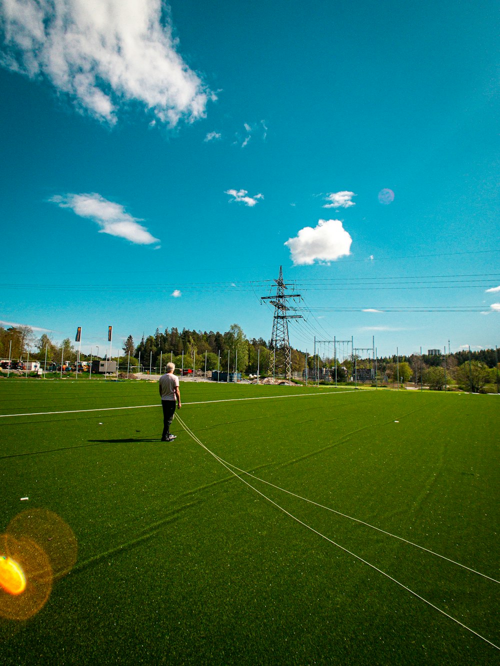 man in white shirt and black pants standing on green grass field during daytime