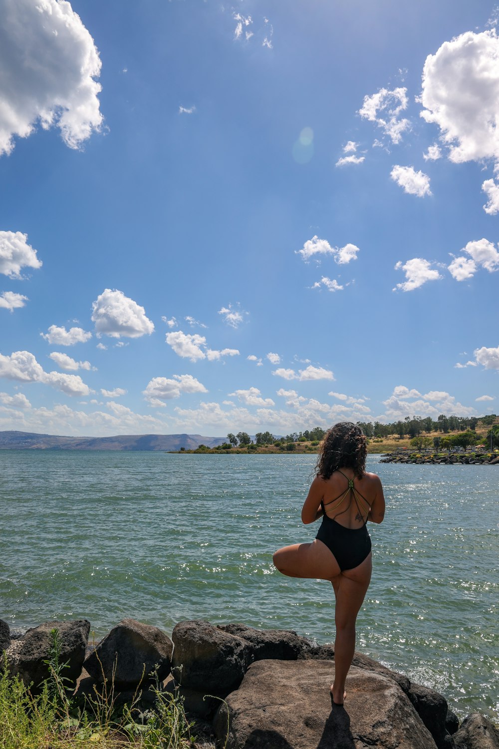 woman in black bikini standing on sea shore during daytime