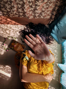 woman in yellow dress lying on bed