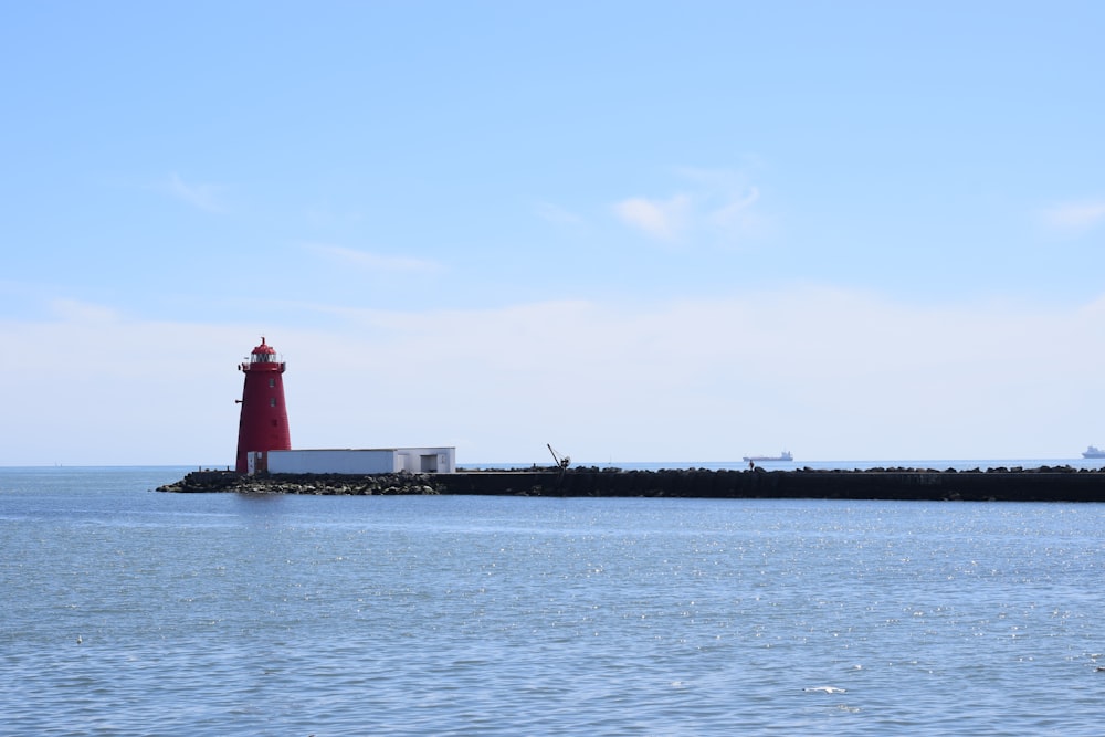 red and black ship on sea under white sky during daytime