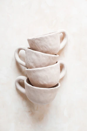 Stacked ceramic cups with subtle textures and soft colors.