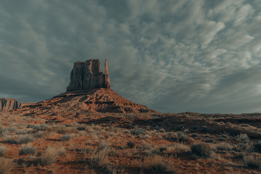 brown rock formation under white clouds