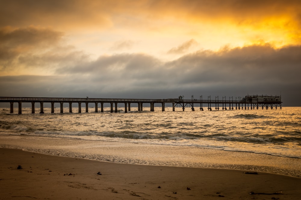 Menschen, die während des Sonnenuntergangs am Strand spazieren gehen