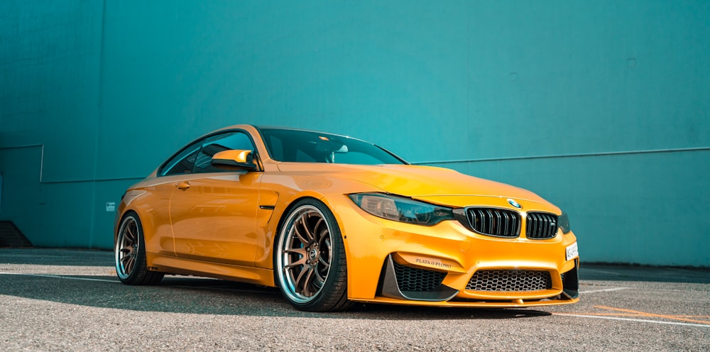 yellow bmw m 3 coupe parked on gray concrete pavement