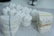 Plaster dental molds are arranged on a gray speckled surface. Some molds are stacked and secured with rubber bands, displaying detailed impressions of teeth.