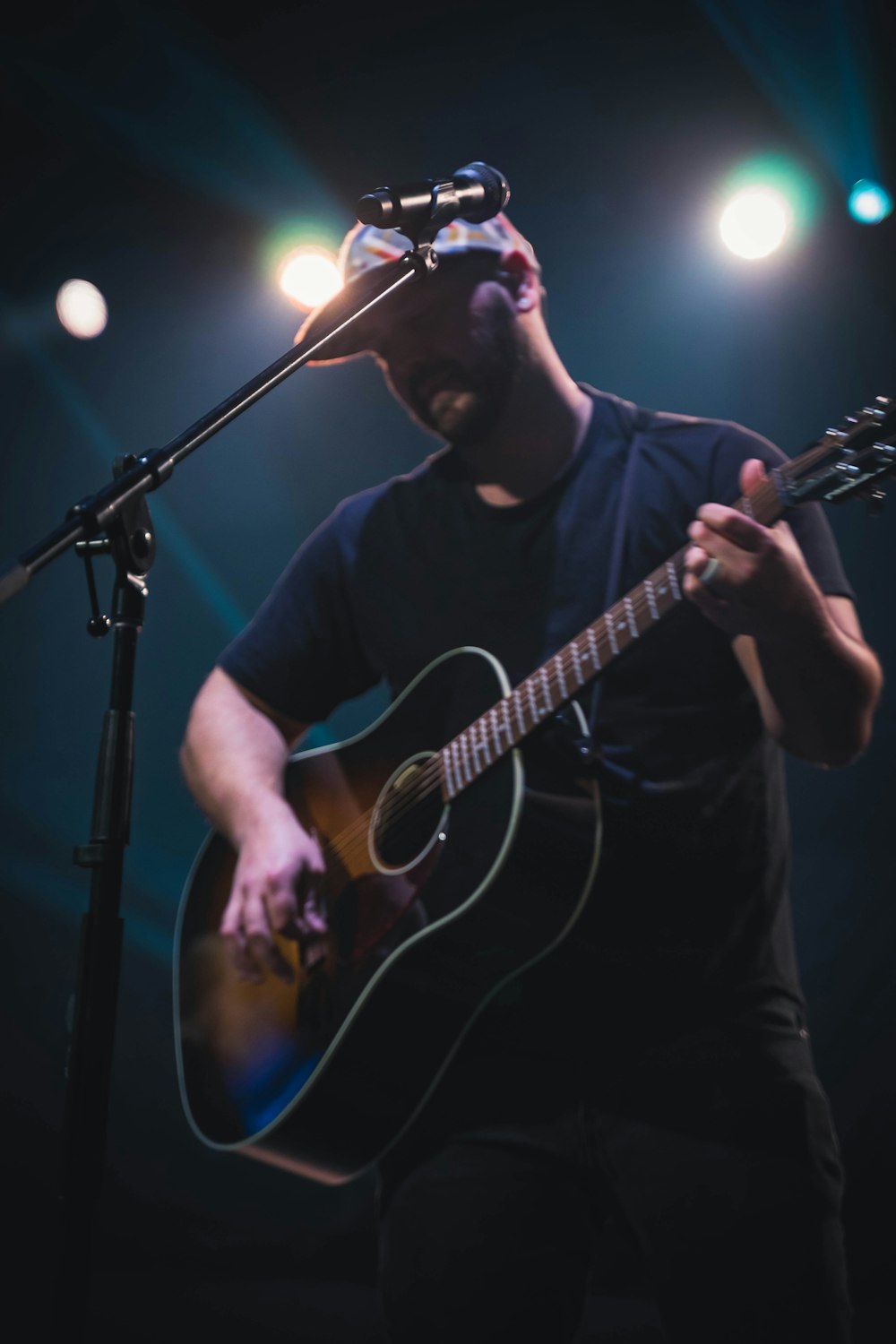 man in black crew neck t-shirt playing acoustic guitar