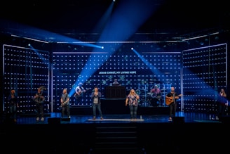 people standing on stage with blue lights