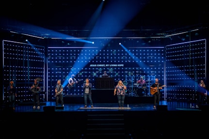 people standing on stage with blue lights