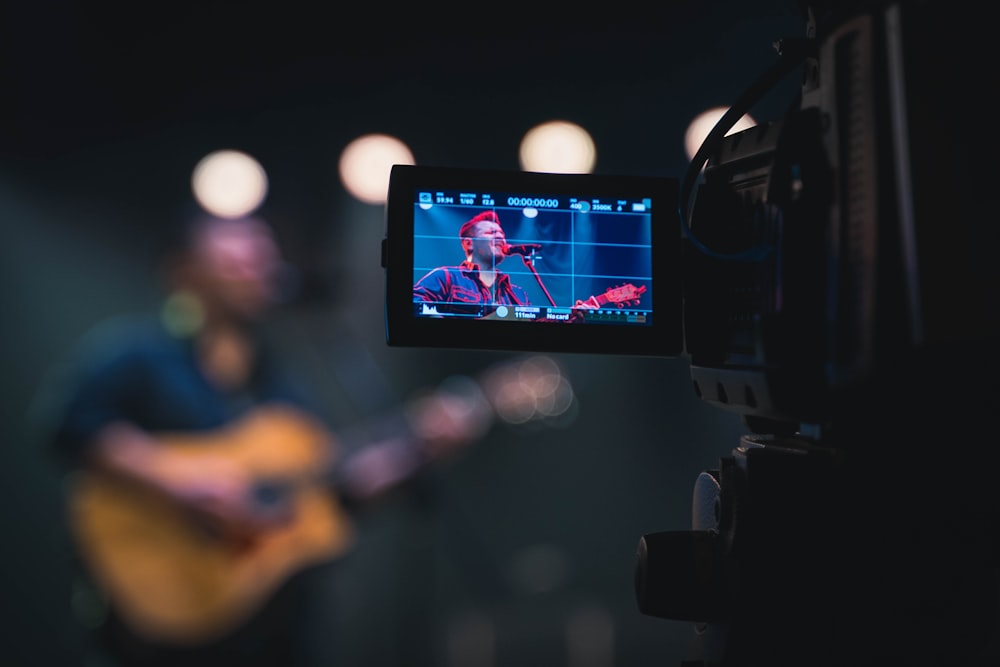 homem que toca guitarra na frente das pessoas