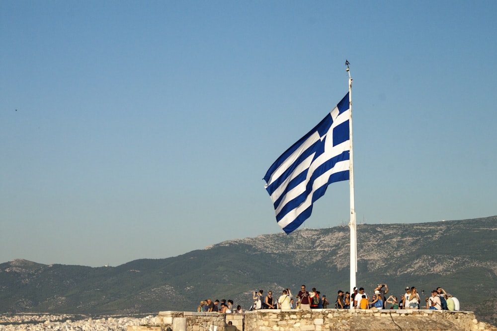 a group of people standing next to a flag