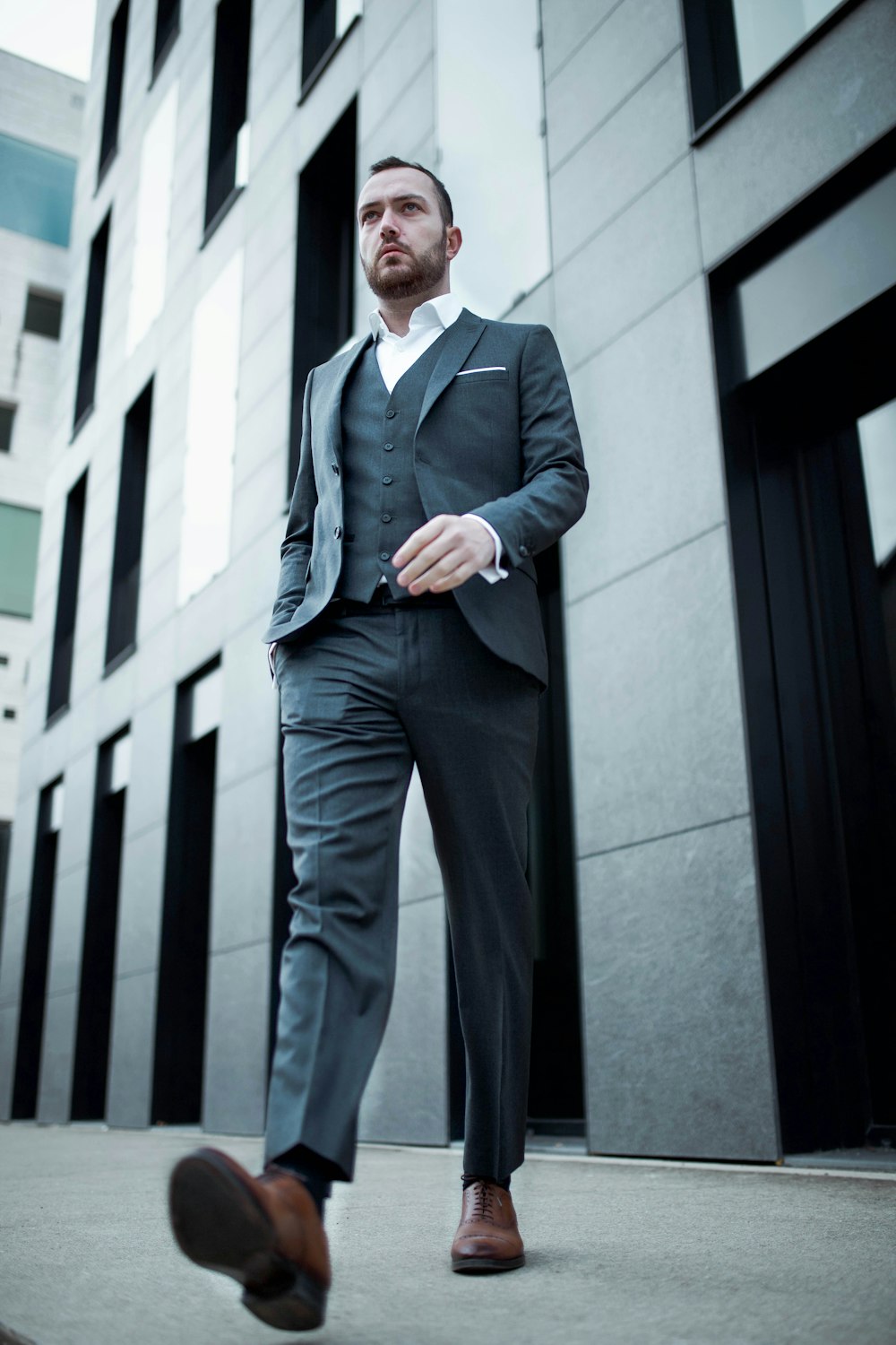 man in blue suit standing near white concrete building during daytime