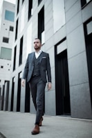 man in black suit standing near black metal gate during daytime