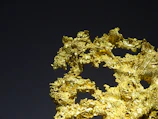 Close-up texture of raw gold mineral shining under natural light.