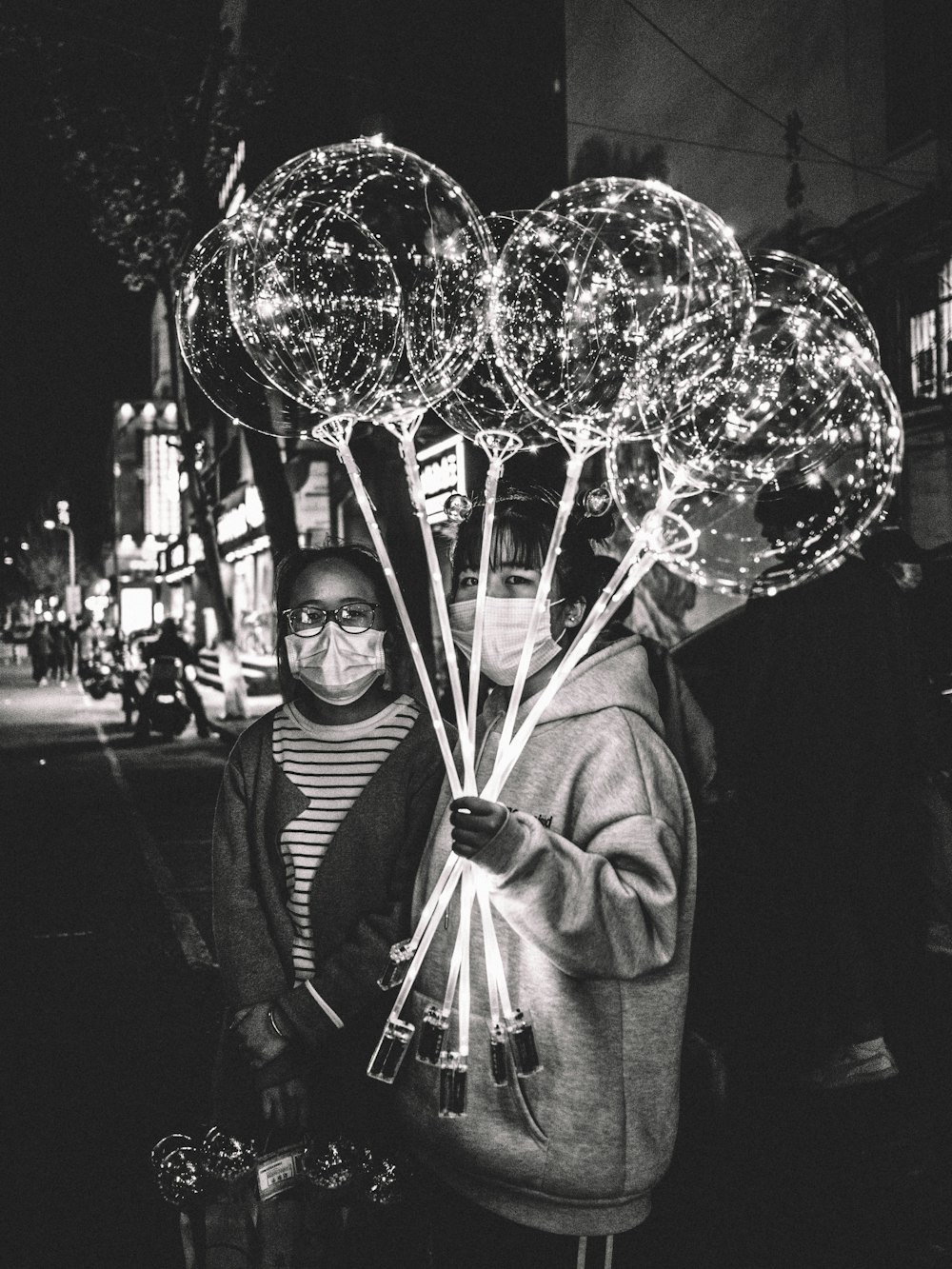 man in black and white striped long sleeve shirt holding balloons