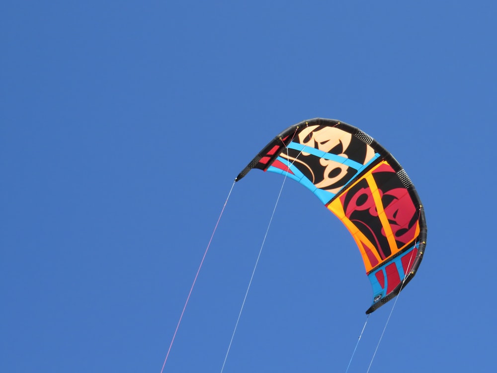 red yellow and blue kite flying under blue sky during daytime