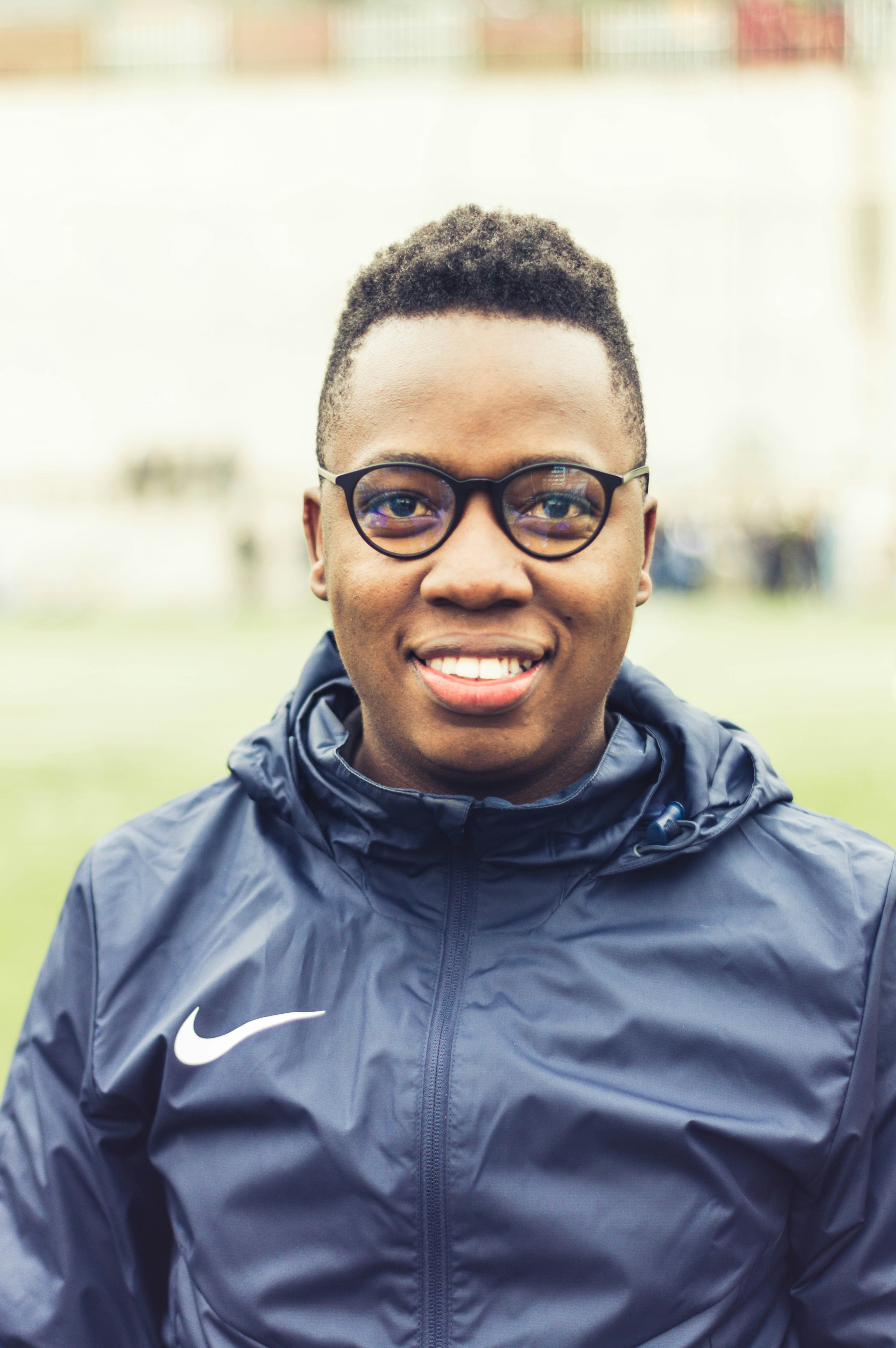 man in black zip up jacket wearing black framed eyeglasses