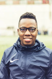 man in black zip up jacket wearing black framed eyeglasses