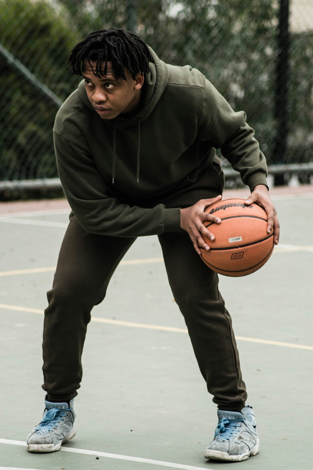 man in black hoodie holding basketball