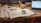 A laptop on a desk with a notepad and coffee, symbolizing online study.